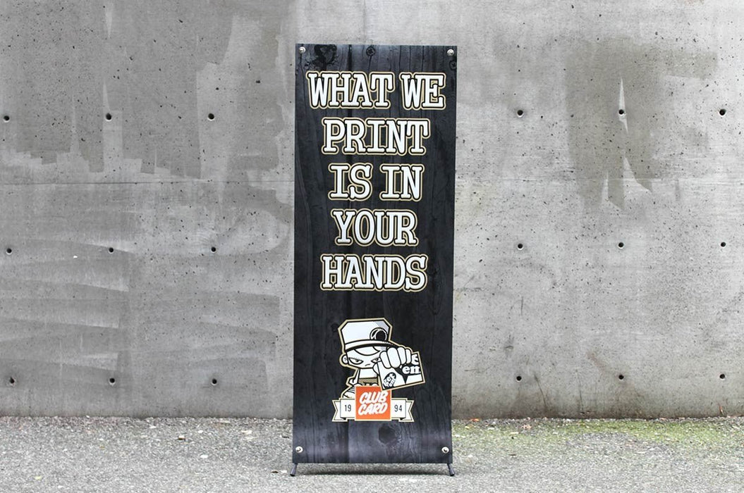 Straight-on front view of a 24x60 outdoor X banner stand with custom printed black vinyl artwork. Clubcard Printing USA