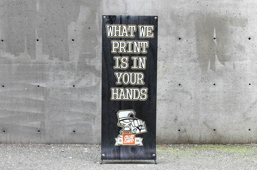 Straight-on front view of a 24x60 outdoor X banner stand with custom printed black vinyl artwork. Clubcard Printing USA