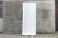 Back view of a 33x80 inch portable retractable banner stand displayed outdoors against a concrete wall. Clubcard Printing USA