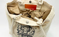 Interior view of an open canvas beach tote bag with snap closure and thick braided rope handles