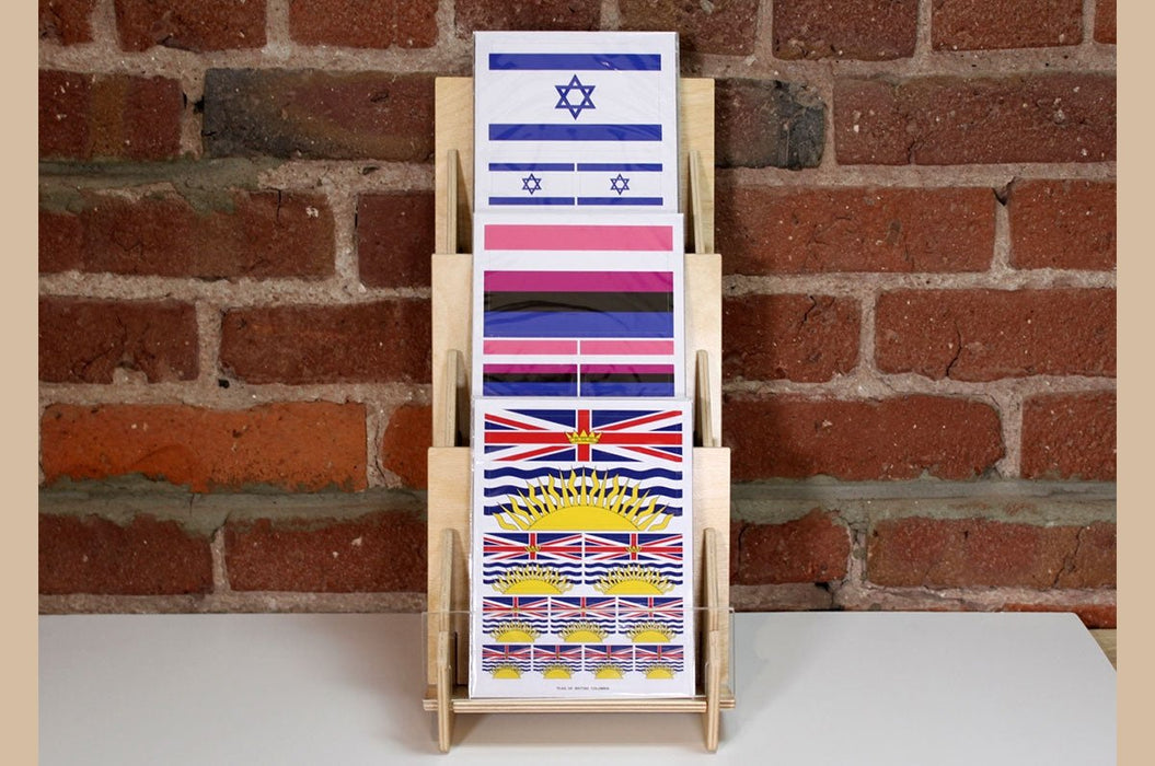 Front view of a 3-tier birch wood slim card display rack filled with flag sticker sheets made in the USA at Clubcard Printing in Palm Springs