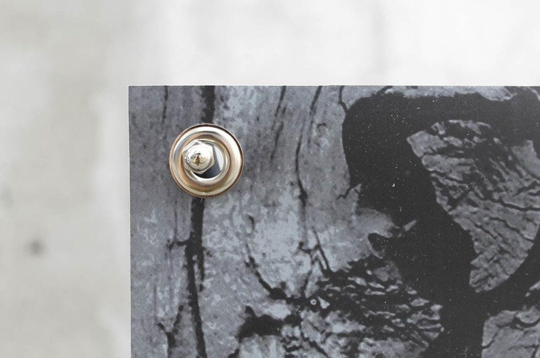 Extreme close-up view of a reinforced brass metal grommet on a custom printed outdoor vinyl banner. Clubcard printing palm springs