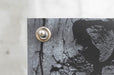 Extreme close-up view of a reinforced brass metal grommet on a custom printed outdoor vinyl banner. Clubcard printing palm springs