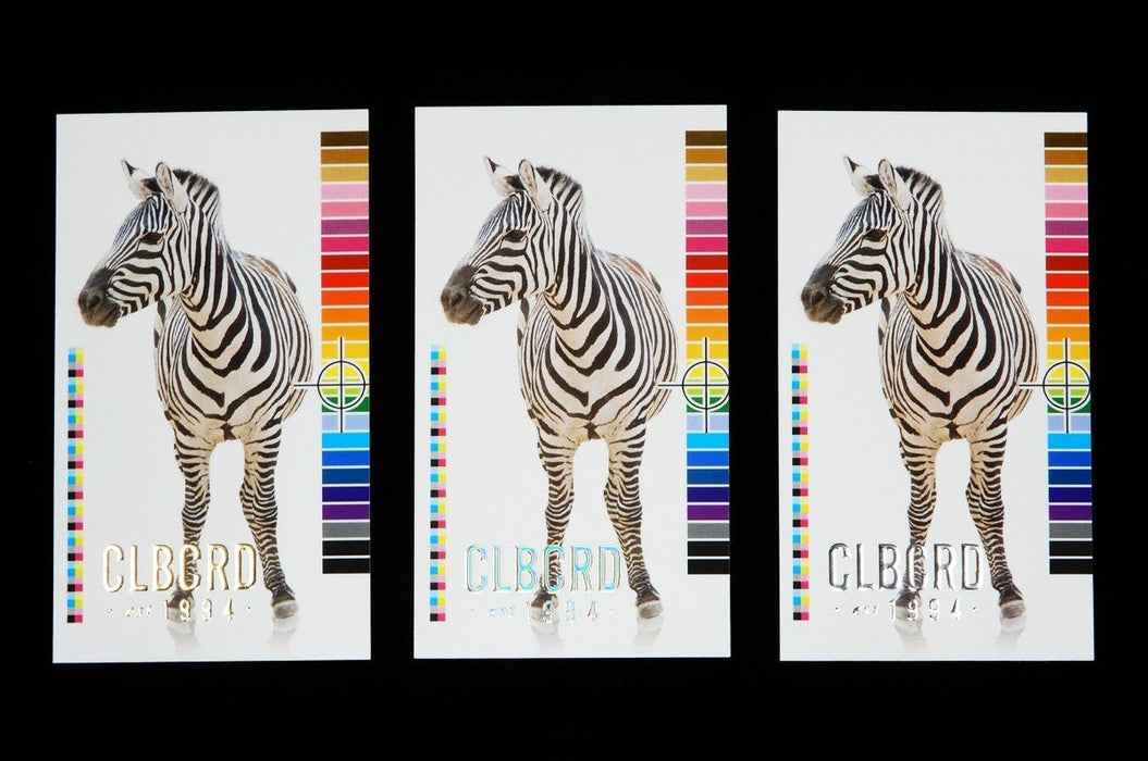 Three Clubcard sample cards on 19pt suede card stock showing zebra graphic with CLUBCARD logo in raised gold, silver, and iridescent metallic foil