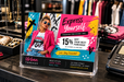 A printed retail display card for Urban Threads in a clear acrylic holder on a store counter, featuring a model in a pink blazer with 'Express Yourself' text, printed by Clubcard Palm Springs on 12pt 100% recycled fibers stock with full color detail.