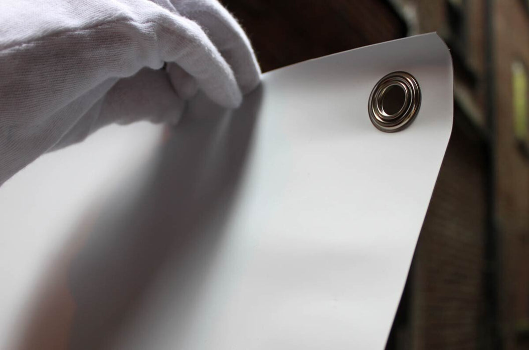 Close-up view of a metal corner grommet installed on a custom printed replacement vinyl banner for X-stand and L-stand displays. Clubcard Printing Palm Springs