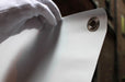 Close-up view of a metal corner grommet installed on a custom printed replacement vinyl banner for X-stand and L-stand displays. Clubcard Printing Palm Springs