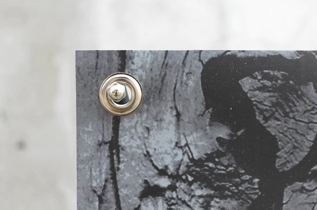 Close-up view of a silver metal screw-in stud connector installed through a corner grommet on a replacement banner. Clubcard Printing