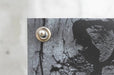 Close-up view of a silver metal screw-in stud connector installed through a corner grommet on a replacement banner. Clubcard Printing