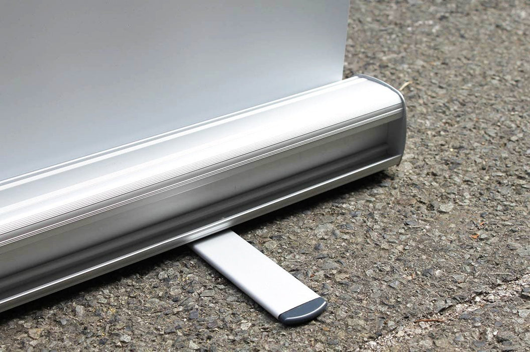 Close-up view of the aluminum base cassette and swivel stabilizing foot of a retractable banner stand. Clubcard Printing USA