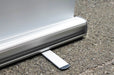Close-up view of the aluminum base cassette and swivel stabilizing foot of a retractable banner stand. Clubcard Printing USA